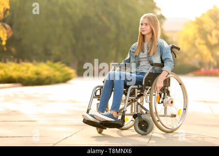 Nettes junges Mädchen im Rollstuhl im Freien Stockfoto