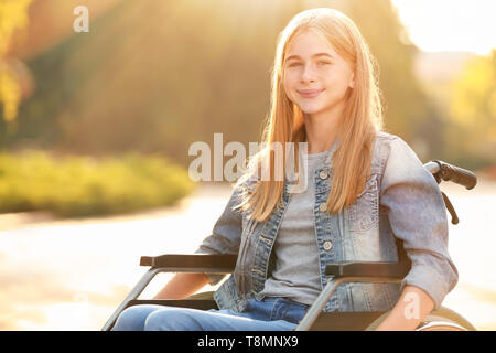 Nettes junges Mädchen im Rollstuhl im Freien Stockfoto