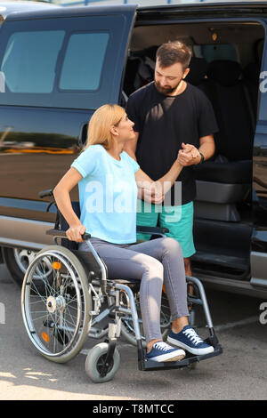 Mann, Frau im Rollstuhl im Auto sitzen zu Stockfoto