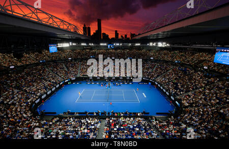 Die Rod Laver Arena bei Sonnenuntergang mit Wahrzeichen von Melbourne Skyline im Hintergrund. Stockfoto