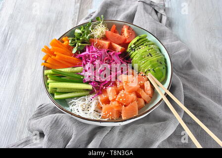 Frische Meeresfrüchte Rezept. Ökologische Lebensmittel. Frischer Lachs poke Schüssel mit Crystal Nudeln, frischen Rotkohl, Avocado, Cherry Tomaten. Essen Konzept poke Schüssel Stockfoto
