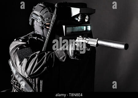 Bewaffneten SWAT fighter Verstecken hinter ballistischer Schutz Stockfoto