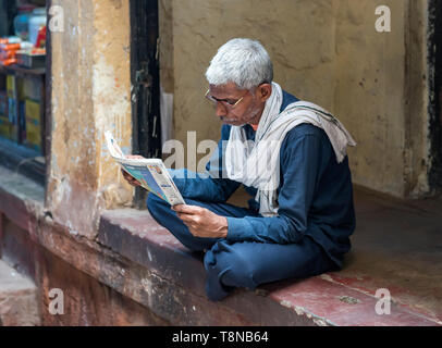 Mann liest Zeitung, alte Stadt Varanasi, Indien Stockfoto