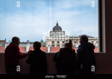 Menschen, die eine Stadt betrachten, Rückansicht von vier Personen im Leopold Museum in Wien mit Blick auf Stadtgebäude, Wien, Österreich. Stockfoto