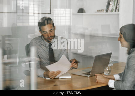 Content Manager Lesen eines Bewerbers Lebenslauf in einem Interview Stockfoto