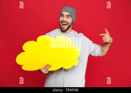 Bild von optimistischen Mann 30 s tragen Hut holding Nachricht Blase über den roten Hintergrund isoliert Stockfoto