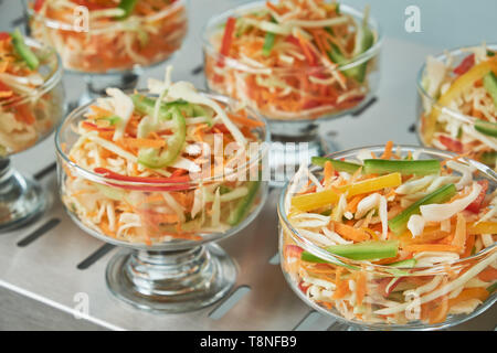 Schaufenster Kühlschrank für die Verpflegung mit warmen Speisen. Süße Desserts, warme Speisen und Salate. Stockfoto