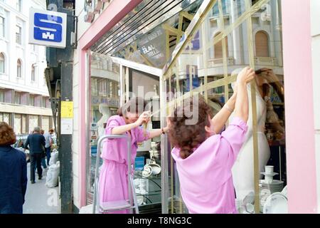 Zwei Frauen, die Band über ein Schaufenster in der kroatischen Hauptstadt Zagreb gegen Bombe Schäden durch Luftangriffe während des serbisch-kroatischen Krieg zu Guard in 1991-92. Bild von Adam Alexander Stockfoto