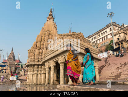 Zwei Frauen in traditionellen Sari Kleid vor dem schiefen Ratneshwar Mahadev Tempel, Varanasi, Indien Stockfoto