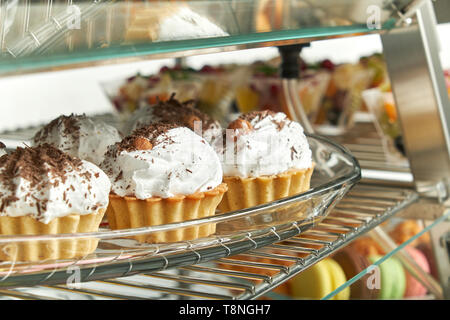 Schaufenster Kühlschrank für die Verpflegung mit warmen Speisen. Süße Desserts, warme Speisen und Salate. Stockfoto