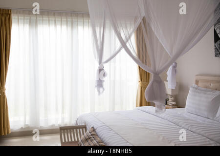 Minimalistischen skandinavischen Interieur mit Design Sofa, tropischen Pflanzen, Couchtisch, Liebe unterzeichnen und Kerzen. Bali Style interior Stockfoto