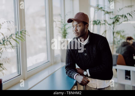 Portrait von nachdenklich afrikanischen amerikanischen Geschäftsmann, stehen in der Nähe der Fenster und das Denken über die Entscheidung, träumen von Erfolg, Nachdenken neuer Anlauf. Handsom Stockfoto