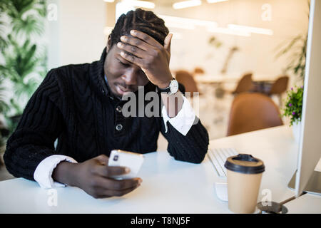 Schön müde Afro-amerikanische Geschäftsmann in legere Kleidung ist das Massieren Nasensteg, während Sie mit einem Laptop arbeiten zu Hause Stockfoto