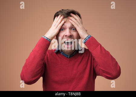 Traurig reifer Mann hielt seinen Kopf in den Händen und Schreien Stockfoto