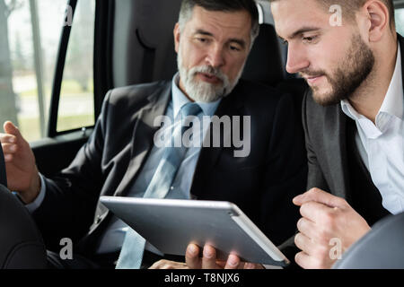 Kollegen Diskussion von Ideen während der Sitzung in Rücksitz des Autos oder mit dem Taxi. Stockfoto