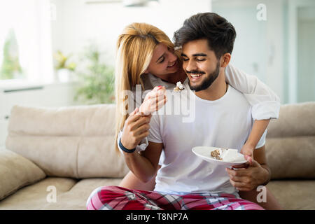 Liebevolle glückliches Paar in ihren Schlafanzügen essen Frühstück Stockfoto