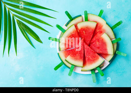 Wassermelone auf einem weißen Teller. Blauen Hintergrund. Ansicht von oben. Kopieren Sie Platz. Stockfoto