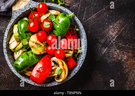 Gegrilltes Gemüse (Paprika, Zucchini, Champignons und Tomaten in einer Pfanne, Ansicht von oben. Gesunde vegane Ernährung Konzept. Stockfoto