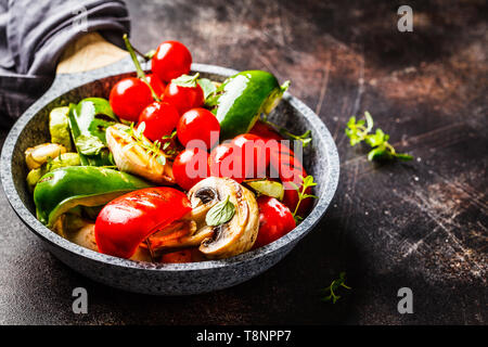 Gegrilltes Gemüse (Paprika, Zucchini, Champignons und Tomaten in einer Pfanne. Gesunde vegane Ernährung Konzept. Stockfoto