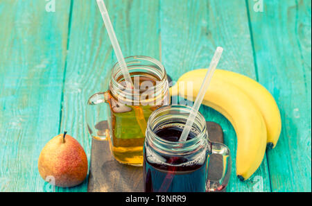 Gläser Saft mit Früchten auf Tisch Stockfoto