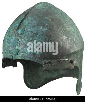 Eine Chalkidian Helm und ein paar Grieben, 4./5. Jahrhundert v. Chr. Bronze. Der Schädel mit einem zentralen Bergrücken und ein ausgeprägt konturierten Giebel, mit PALMETTE eingerichtet, auf der Stirn. Die Giebel in einem großen Spirale Spirale auf jeder Seite. Groß, stark offset Hals-Guard, mit einem querliegenden Verstärkung ausbuchtung und ein Offset von RIM. Genieteten Scharniere für die gebogenen cheekpieces, fragmentarischen Pins für die Anlage. Höhe 24 cm, mit dem cheekpieces 28 cm. Gewicht 876 g. Grün - rotbraune Patina. Die gesamte Helm in wunderbaren metallischen Konservierung, lediglich eine kleine ve, Additional-Rights - Clearance-Info - Not-Available Stockfoto