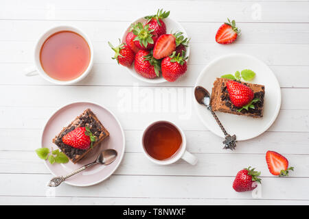 Trüffel Torte mit Schokolade und Erdbeeren und Minze auf eine weiße Holztisch. Selektiver Fokus Stockfoto