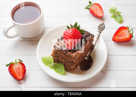 Trüffel Torte mit Schokolade und Erdbeeren und Minze auf eine weiße Holztisch. Selektiver Fokus Stockfoto