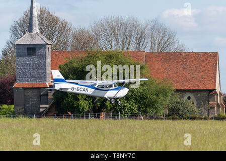 Cessna 172 Skyhawk private Ebene G-ECAK Landung am Flughafen London Southend, Essex, Großbritannien. St Laurence & All Saints Church in der Nähe von airport Stockfoto