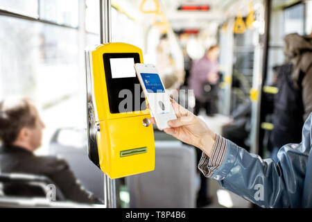 Zahlen conctactless mit Smartphone für die öffentlichen Verkehrsmittel in der Straßenbahn, Nahaufnahme Stockfoto