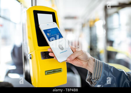 Zahlen conctactless mit Smartphone für die öffentlichen Verkehrsmittel in der Straßenbahn, Nahaufnahme Stockfoto