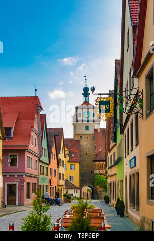 Schöne Aussicht auf eine typische Gasse in Rothenburg o.d. Tauber, Deutschland mit bunten Häusern. Der gepflasterten Straße Georgengasse führt zu einem Gate Tower mit einem... Stockfoto