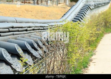 Die niedrige Gartenmauer mit koreanischen traditionellen Dachziegeln gedeckt Stockfoto