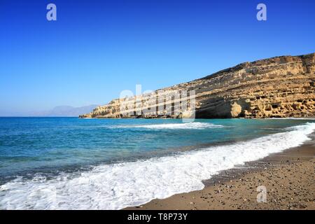 Matala, Kreta - Blick auf den Strand mit Hippie Höhlen im Hintergrund. Stockfoto