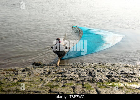 Fischer versuchen, Fische aus dem Fluss mit Fischernetz zu sammeln. Stockfoto