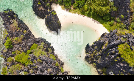 Nationalpark El Nido Palawan Philippinen. Warme versteckte Lagune in der Nähe der Felsen. Touristen am weißen Strand zu entspannen. Touristische Routen in den Philippinen. Felsformationen an einem tropischen Strand. Stockfoto