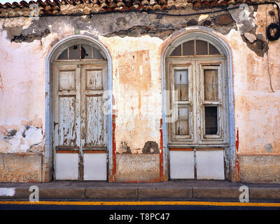 Vorderansicht eines alten, baufällig und heruntergekommen Old Town House in einem Sebastian' auf 'La Gomera' (Kanarische Insel). bröckelnden Putz und zwei gewölbte Entra Stockfoto