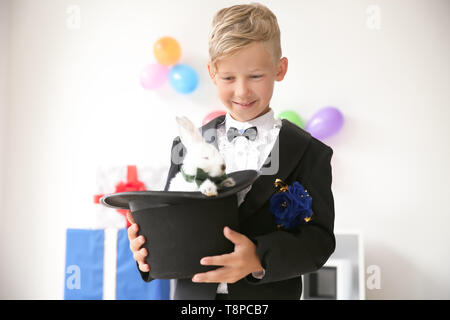 Süße kleine Magier Holding hat mit Hase im Innenbereich Stockfoto