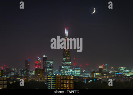 Ein Halbmond über den Shard Hochhaus in der Woche ab Ramadan, London, UK gesehen. Stockfoto