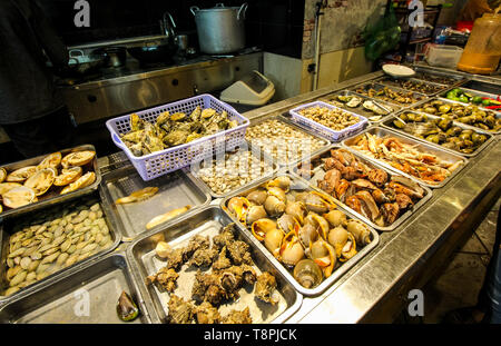 Street Food in der Nacht in Vietnam. Köstliche Meeresfrüchte für Touristen auf der Straße. Frische Muscheln und musles Sortiment. Stockfoto