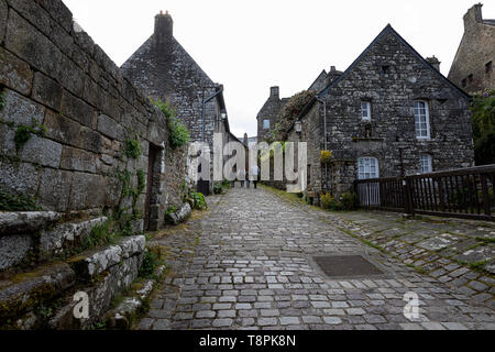 Familie von vier gehen auf gepflasterten Straße in erhaltenen mittelalterlichen Dorf von Locronan in der Bretagne, Frankreich. Département Finistère. Stockfoto