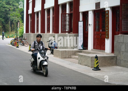 (190514) - Peking, 14. Mai 2019 (Xinhua) - Ratjirot Aekkawat reitet ein Roller auf dem Campus der Universität in Peking in Peking, der Hauptstadt von China, 12. Mai 2019. Ratjirot Aekkawat ist von gemischten Blut aus China und Thailand. Er kam in China als Junior student zu studieren und jetzt ist er ein Nachdiplomstudium in der Peking Universität. Er spricht immer über seine Erfahrungen in China mit Verwandten und Freunden. Er hat die Entwicklung Chinas in den letzten Jahren erlebten, in der die Umwelt und die lokalen Regierungen die Effizienz erheblich verbessert wurden. Chinesische und thailändische Kulturen sind Stockfoto