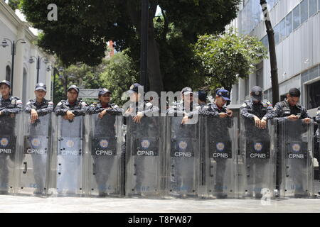 Caracas, Venezuela. 14 Mai, 2019. Polizisten Lachen, während sie den Weg zu der von der Opposition kontrollierte Parlament blockieren. Der offizielle Grund für die Bedienung war die Suche nach einen Sprengsatz in den von der Regierung entmachtet Kongress. Der Leiter des Parlaments und selbst ernannten einstweiligen Präsidenten Guaido beschuldigte Staatschef Maduro, mit der versucht wird, die Regierung - kritischer Parlamentarier mit seiner Mission einzuschüchtern. Credit: Rafael Hernandez/dpa/Alamy leben Nachrichten Stockfoto