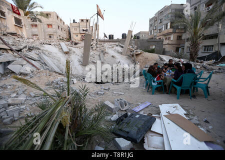 In Gaza. 14 Mai, 2019. Familie Mitglieder der Palästinensischen Mousa Zorub haben ihre Frühstück neben ihren zerstörten Haus im südlichen Gazastreifen Stadt Rafah, am 14. Mai 2019. Das Hilfswerk der Vereinten Nationen für Palästinaflüchtlinge im Nahen Osten (UNRWA) am Montag gesagt, dass mehr als die Hälfte der Bevölkerung im Gazastreifen nicht genug Nahrung bis Juni haben. Quelle: Xinhua/Alamy leben Nachrichten Stockfoto