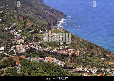 Blick in die kleinen Dörfer der Anagagebirge auf Teneriffa von oben, plus die üppige grüne Vegetation, bunten Häuschen und einem blauen Atlantik Stockfoto