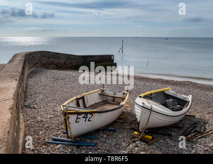 Fischerboote Hochgezogen an der Küste neben einem Sea Wall in Honiton, Devon, Großbritannien Stockfoto