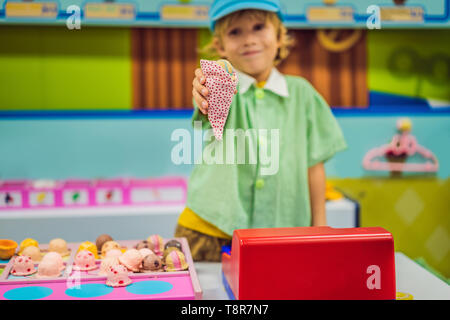 Ein Junge spielt in einem Spielzeug Küche, macht ein Spielzeug Eiscreme Stockfoto