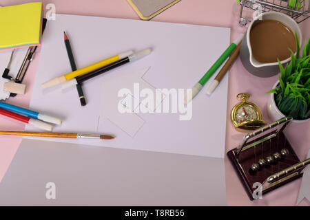 Ansicht von oben in das Schneiden von Papier oder Zeichnung Haus auf einem rosa Tabelle, die Vorbereitung von Hausaufgaben in einer offenen Notebook zu tun. Zeichnung Schreibtisch Konzept. Stockfoto