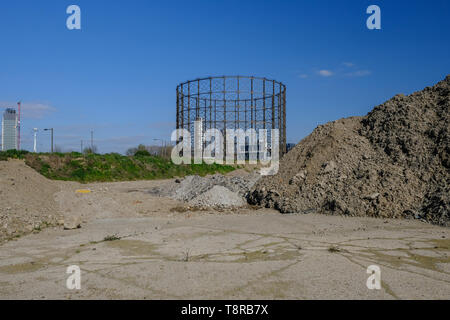 Stapel der Erde mit einem Betonsockel im Vordergrund und ein Altes Gaswerk in den Hintergrund. Website für zukünftige Bau vorbereitet. Stockfoto