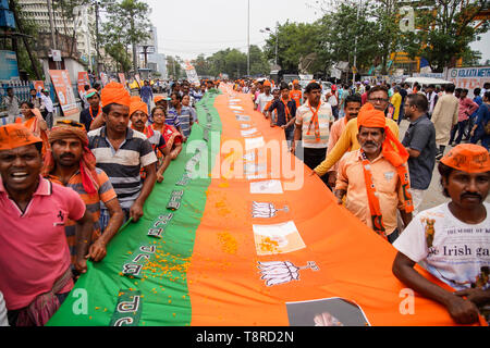 Bharatiya Janta Party oder BJP Anhänger gesehen, die eine riesige Flagge während der Show in Kalkutta. Bharatiya Janata Party (BJP) Präsident Amit Shah am Dienstag hielt ein mega-Roadshow in Kolkata mit Unterstützung von Kandidaten der Partei vor dem abschließenden Phase der Lok Sabha Umfragen. Stockfoto