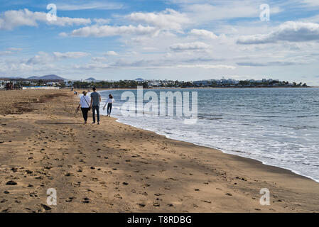 Lanzarote, Kanarische Inseln, Spanien. Provinz Las Palmas. Touristen auf dem Sandstrand, Vulkangestein. Stockfoto